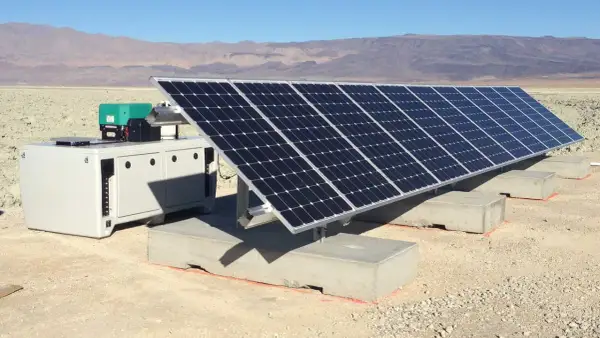 Un impianto fotovoltaico ad isola in un paesaggio arido, con pannelli solari e un'unità di controllo. Le autorizzazioni per questo sistema sono fondamentali per l'energia sostenibile.