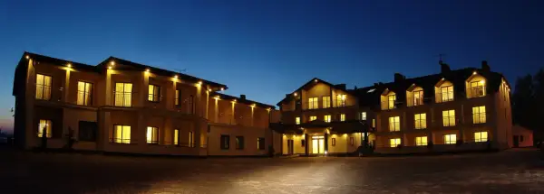 Hotel Rusałka w Okunince nocą, oświetlony, z widokiem na fasadę i balkony.