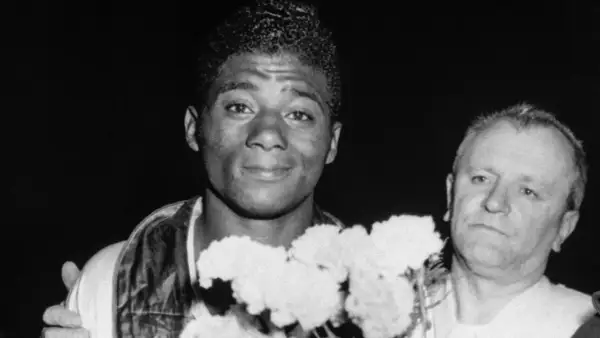 Floyd Patterson, a young boxer, smiles with flowers. His weight was a key factor in his championship wins.