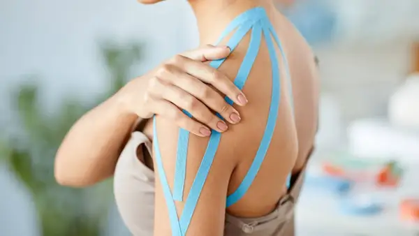 Schulter mit blauem Kinesio-Tape, das den Bereich des plexus brachialis unterstützt.