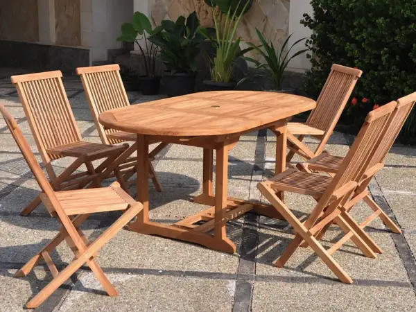 Ensemble de jardin en teck matière, table ovale et chaises pliantes, parfait pour profiter du soleil.