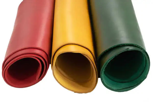 Trois rouleaux de cuir végétal aux couleurs vives : rouge, jaune et vert. Parfait pour vos créations artisanales.