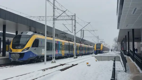Pociągi PKP na trasie Kraków-Oświęcim przez Skawinę stoją na zaśnieżonej stacji.