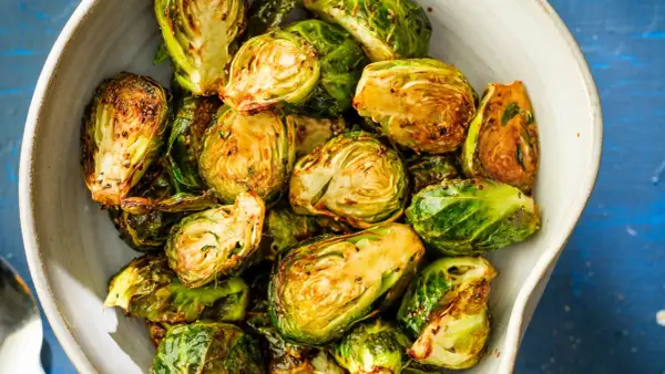 Krispiga och gyllene brysselkål i airfryer, serverade i en skål. Perfekt tillbehör!