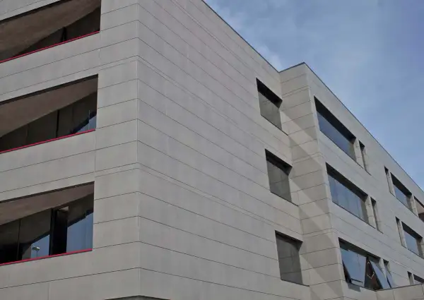 Edificio moderno con fachada de gres porcelánico para fachadas exteriores, líneas horizontales y ventanas oscuras.