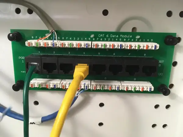 Panel sieciowy Cat 6 z portami RJ45. Widoczne okablowanie i złącza, standard okablowania RJ45 a czy b jest kluczowy dla poprawnego działania sieci.