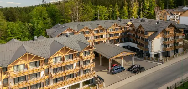 Nowoczesny hotel Platinum Mountain & Spa w otoczeniu lasu. Elegancka architektura z drewnianymi elementami i licznymi balkonami.