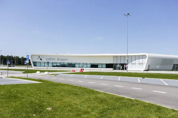 Nowoczesny budynek lotniska Lublin Airport w Świdniku. Widok na parking i drogę prowadzącą do terminala, gdzie oczekiwane są przyloty.