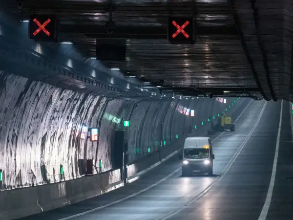 Ein Van fährt durch den beleuchteten **Tunnel Usedom**, während rote X-Zeichen über der Fahrbahn auf eine Sperrung hinweisen.