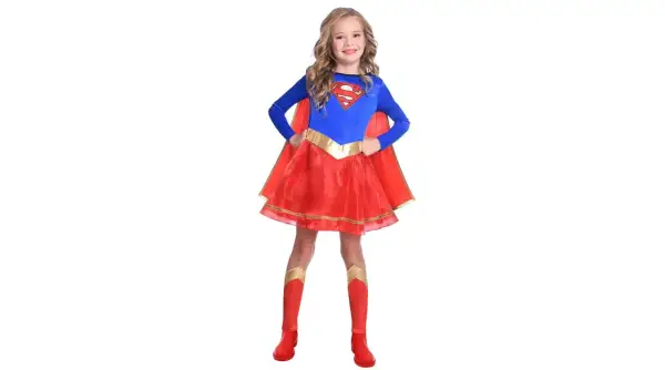 Dziewczynka w stroju Supergirl, idealnym na bal przebierańców. Czerwona spódniczka i peleryna, niebieska bluzka z logo S.