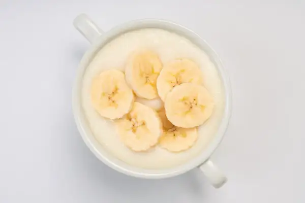Kremowa owsianka z plasterkami banana. Idealne śniadanie, które doda energii na cały dzień. Maseczka z banana na talerzu.