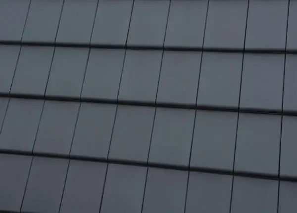 Zbliżenie na ciemnoszare dachówki ułożone w rzędy.