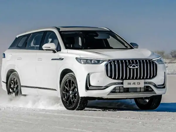 Biały Tiggo 9 pokonuje śnieżne tereny, prezentując swój imponujący grill i elegancką sylwetkę.