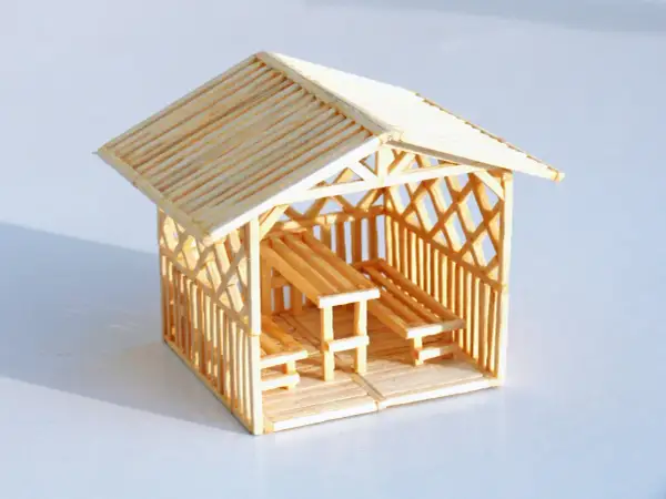Miniaturowy domek z zapałek z ławkami i stołem. Inspiracja, jak zrobić domek z zapałek.
