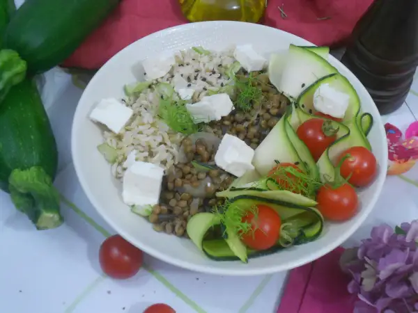 Salade de lentilles, riz, courgettes en rubans, tomates cerises et cubes de feta. Une assiette colorée et saine.