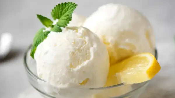 Delicioso helado casero de limón, servido en copa con menta y rodaja de limón. ¡Perfecto para aprender como hacer helado casero!