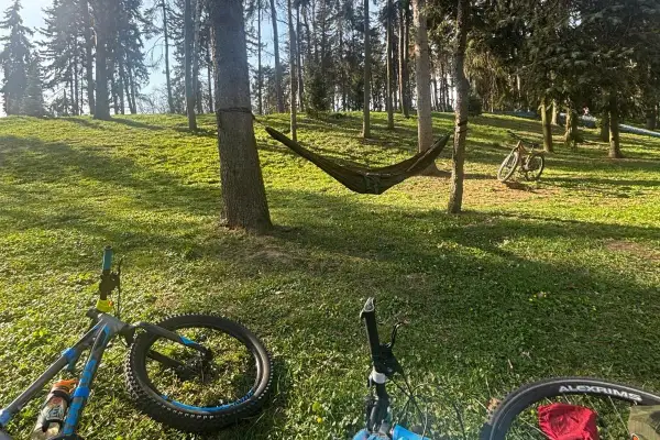 Relaks po rowerowej wycieczce po Warszawie. Hamak między drzewami, rowery czekają na dalszą trasę.