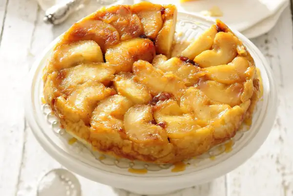 Apetyczna tarta tatin z karmelizowanymi jabłkami, podana na paterze.