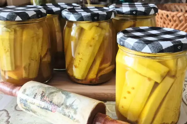 Słoiki z cukinią w zalewie słodko-kwaśnej z curry, gotowe do spiżarni.