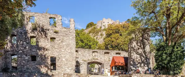 Ruinen der Hohentwiel Burg thronen auf einem Hügel. Im Vordergrund ein Torbogen und ein kleiner Kiosk.