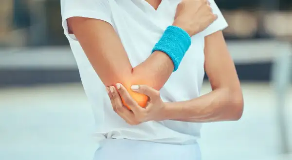 Schmerzende Ellenbeuge bei einem Sportler. Tennisarm tapen sinnvoll zur Entlastung.