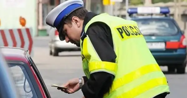 Policjant wręcza mandat. Zastanawiasz się, co jeśli nie zapłacę mandatu w ciągu 7 dni? Lepiej tego nie sprawdzać.