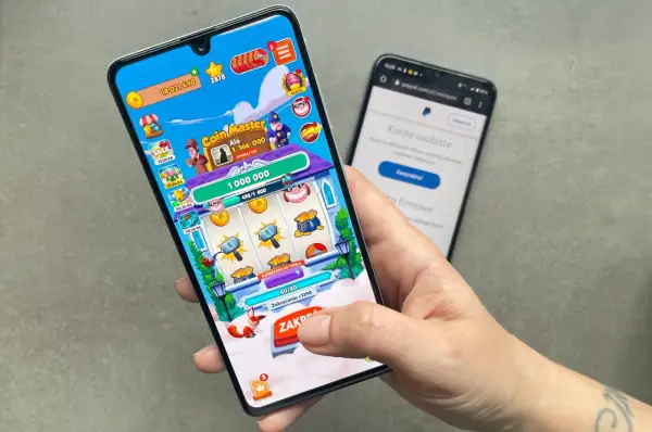Gra Coin Master na telefonie, obok ekran z PayPal. To jedne z gier do zarabiania pieniędzy, które pozwalają na zdobywanie wirtualnych środków.