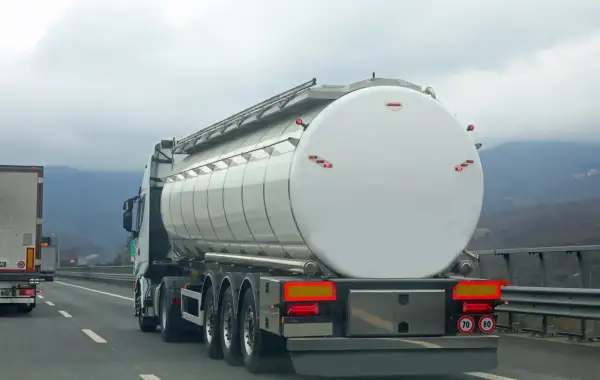 Camion-citerne blanc sur l'autoroute, prêt pour le transport. L'autorisation de rouler pour les camions est essentielle pour la logistique.