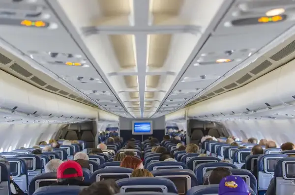 Wnętrze samolotu Ryanair Boeing 737-800. Widok na rząd siedzeń i pasażerów.