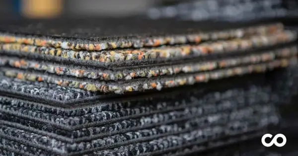 Échantillons de moquette empilés, montrant la texture et les couleurs variées. Une vision claire de la durée de vie d'une moquette.