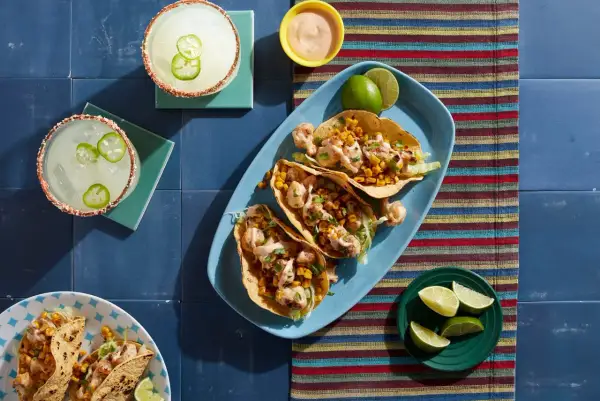 Tacos z kalafiorem i kukurydzą, margarity z papryczką jalapeno na niebieskim tle.