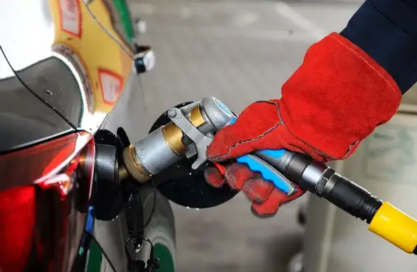Ręka w czerwonej rękawicy podłącza pistolet do tankowania LPG. To proste tankowanie dla początkujących.