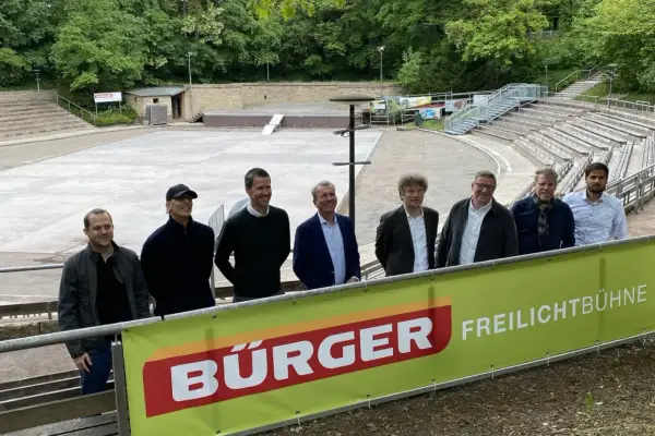 Sieben Männer stehen vor einer Freilichtbühne am Killesberg. Die Banner deuten auf bevorstehende Killesberg Veranstaltungen heute.