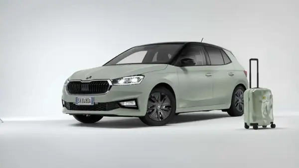 La Skoda Fabia 2026, color verde pastello con tetto nero, è pronta per un viaggio. Accanto, una valigia verde con la scritta "Find your way".