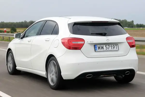 Biała Mercedes A-klasa w ruchu. Analiza wad i zalet tego modelu na drodze.
