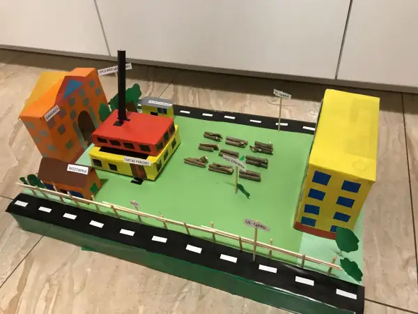Model miasta z budynkami, tartakiem i stertami drewna. Może posłużyć jako inspiracja do wypracowań o chłopcach z Placu Broni dla klasy 5.
