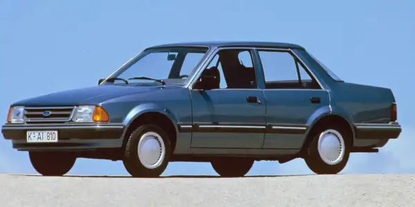 Niebieski Ford Orion z lat 80. na tle błękitnego nieba. Klasyk z przeszłości, który wciąż budzi nostalgię.