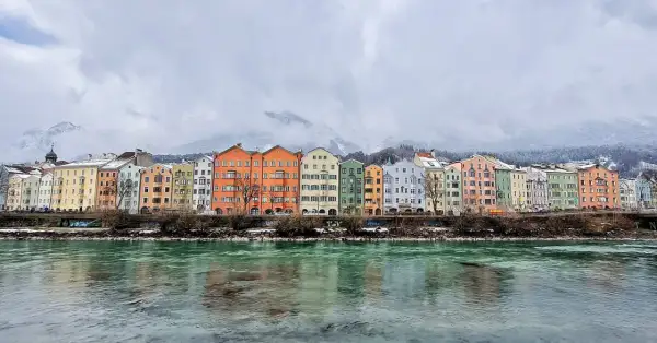 Kolorowe kamienice nad rzeką Inn, w tle ośnieżone góry. Idealne miejsce, by zobaczyć Innsbruck.