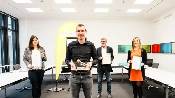 Glückliche Absolventen mit Urkunden und Pokal. Gute Aussichten für die Elektroniker Ausbildung Gehalt Bayern.