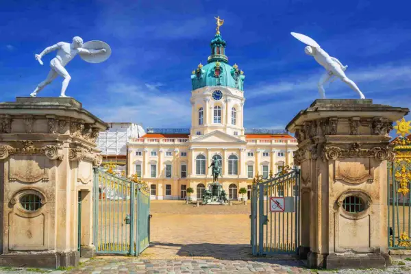 Pałac Charlottenburg w stylu rokoko, z bramą i posągami strażników.