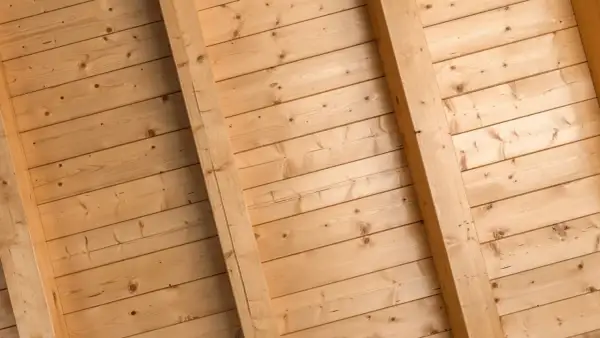 Holzdeckenpaneele mit sichtbaren Balken, bereit zum Streichen. Natürliche Holzmaserung.