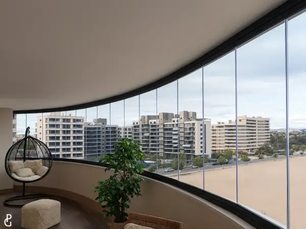 Modernas ideas para cerrar balcones: un espacio acogedor con silla colgante y vistas urbanas.