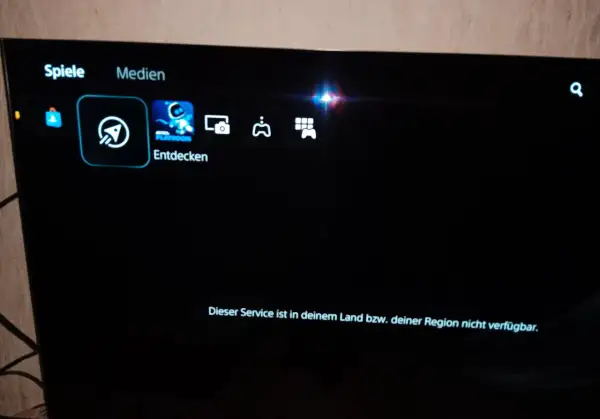 PS5-Menü mit "Spiele" und "Medien". "Entdecken" ist ausgewählt. Eine Meldung besagt: "Dieser Service ist in deinem Land bzw. deiner Region nicht verfügbar.