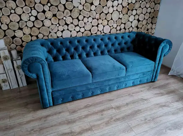 Elegancka kanapa chesterfield w kolorze turkusowym, idealna do salonu. To przykład wysokiej jakości produkcji mebli tapicerowanych.