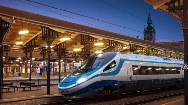 Nowoczesny pociąg EIP PKP Intercity na tle zabytkowego dworca w Gdańsku.