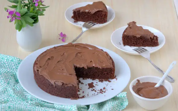 Una deliziosa torta al cioccolato senza glutine, con una fetta mancante e altre due servite su piattini, pronte per essere gustate.