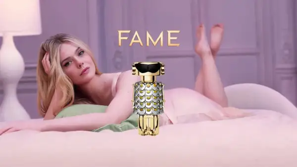 Elle Fanning w łóżku z flakonem perfum FAME Paco Rabanne.