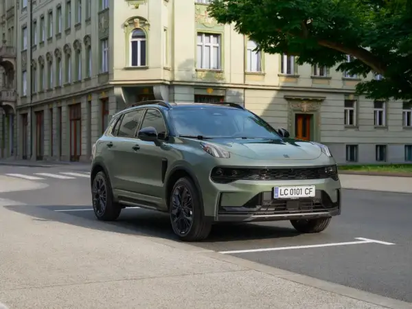 Zielony Lynk & Co SUV zaparkowany na ulicy przed zabytkową kamienicą.