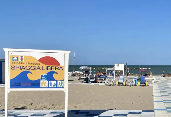 Cartello "Spiaggia Libera" a Porto San Giorgio, con simboli per accessibilità e famiglie.