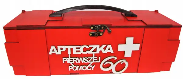 Czerwona, drewniana apteczka z napisem "Apteczka pierwszej pomocy" i białym krzyżem. Idealny prezent dla 60-latki.